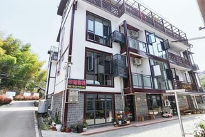 Un immeuble à plusieurs étages dont le rez-de-chaussée est occupé par un commerce.