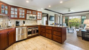Una cucina moderna con elettrodomestici in acciaio inossidabile, mobili in legno e una grande isola.