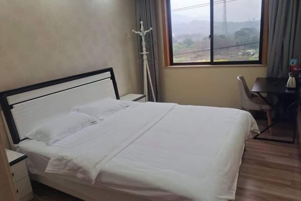 Una habitación de hotel con una cama, un escritorio y una silla.