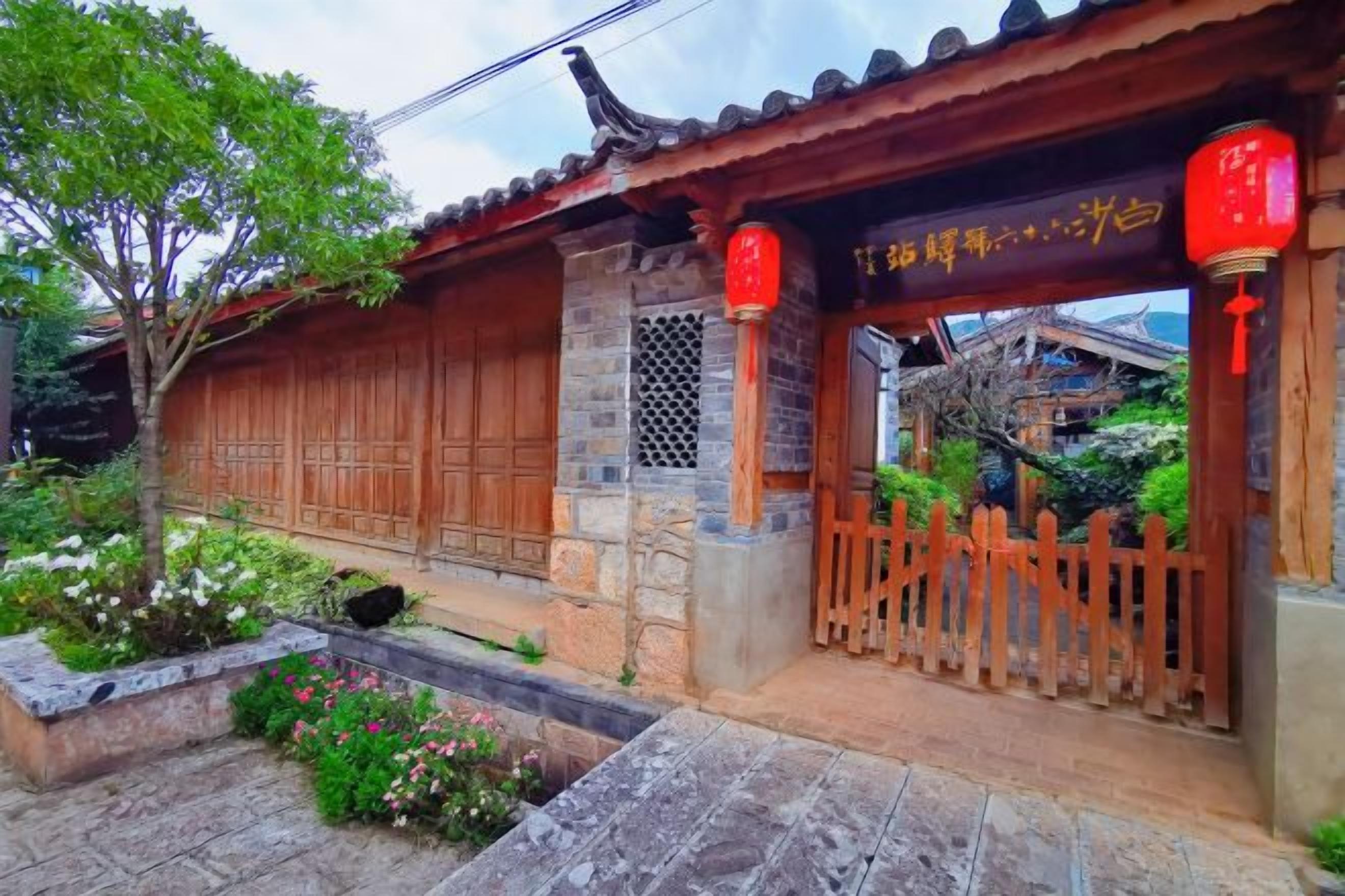 A traditional Chinese building with a wooden gate, stone steps, and a red lantern.