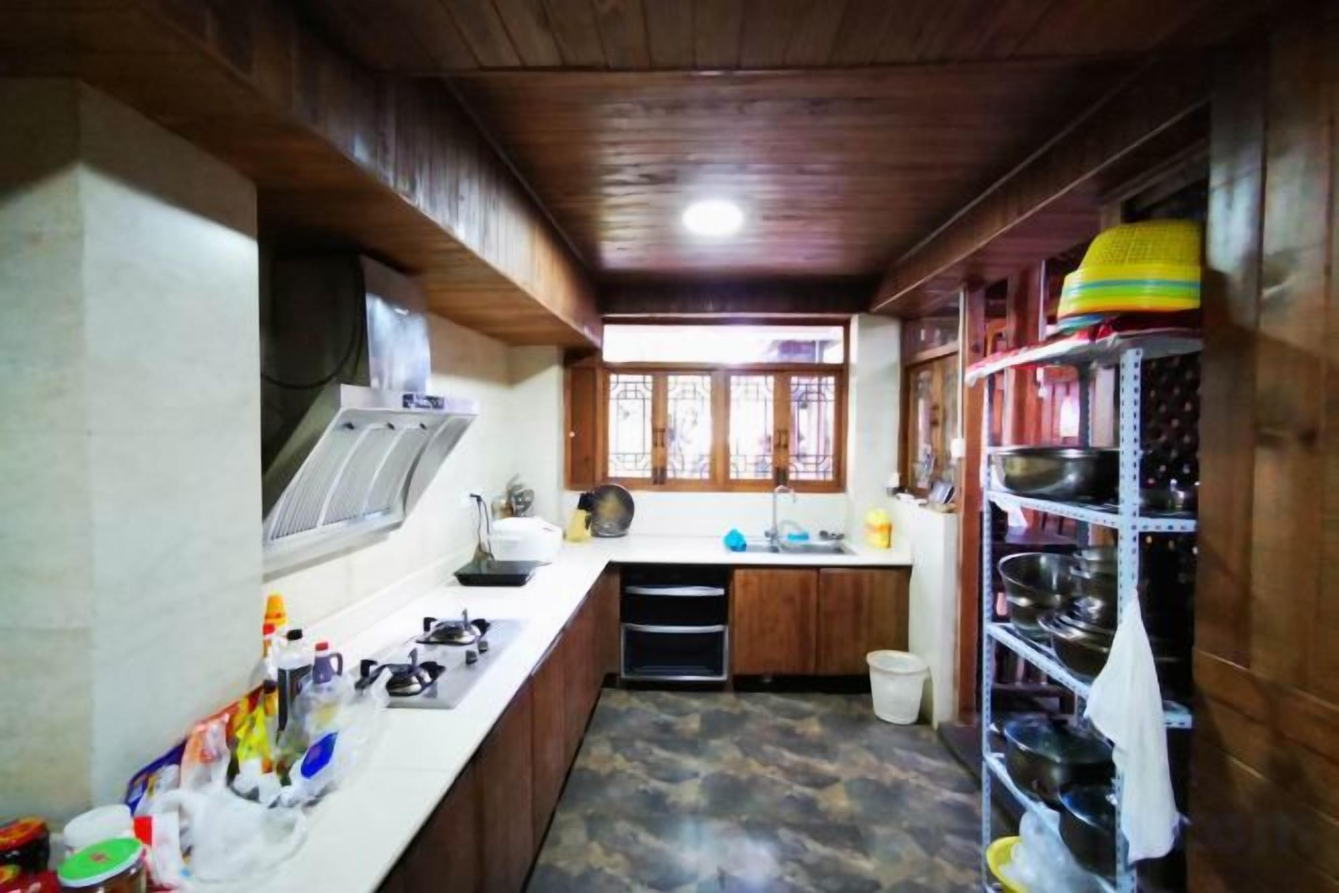 A compact kitchen with wooden cabinets, a sink, and a stove.
