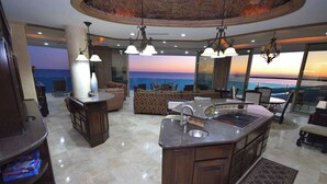 A modern kitchen with a large island, a dining area with a view, and a cozy seating area.