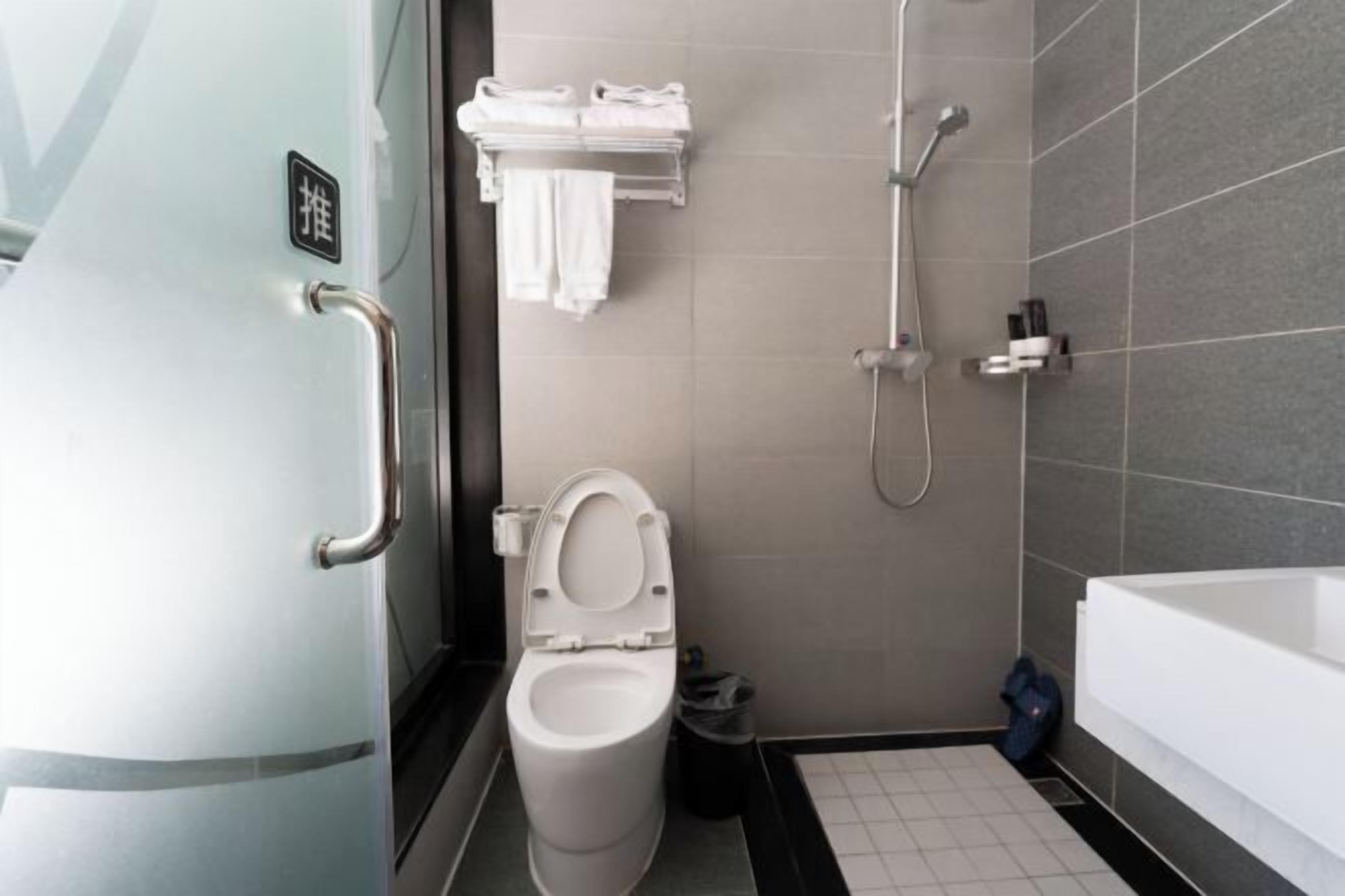 Et moderne badeværelse med toilet, brusebad og badekar.