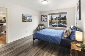 Ein Schlafzimmer mit einem Bett, einem Fenster mit Aussicht und einem Sessel.