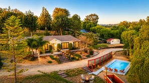A house with a swimming pool, outdoor seating, and a red fence. - 25% Off Oct 29-31, Perfect For Families, W/Pool! (Temecula)