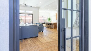Een modern interieur met een grijze bank, houten vloeren en een plafondventilator.