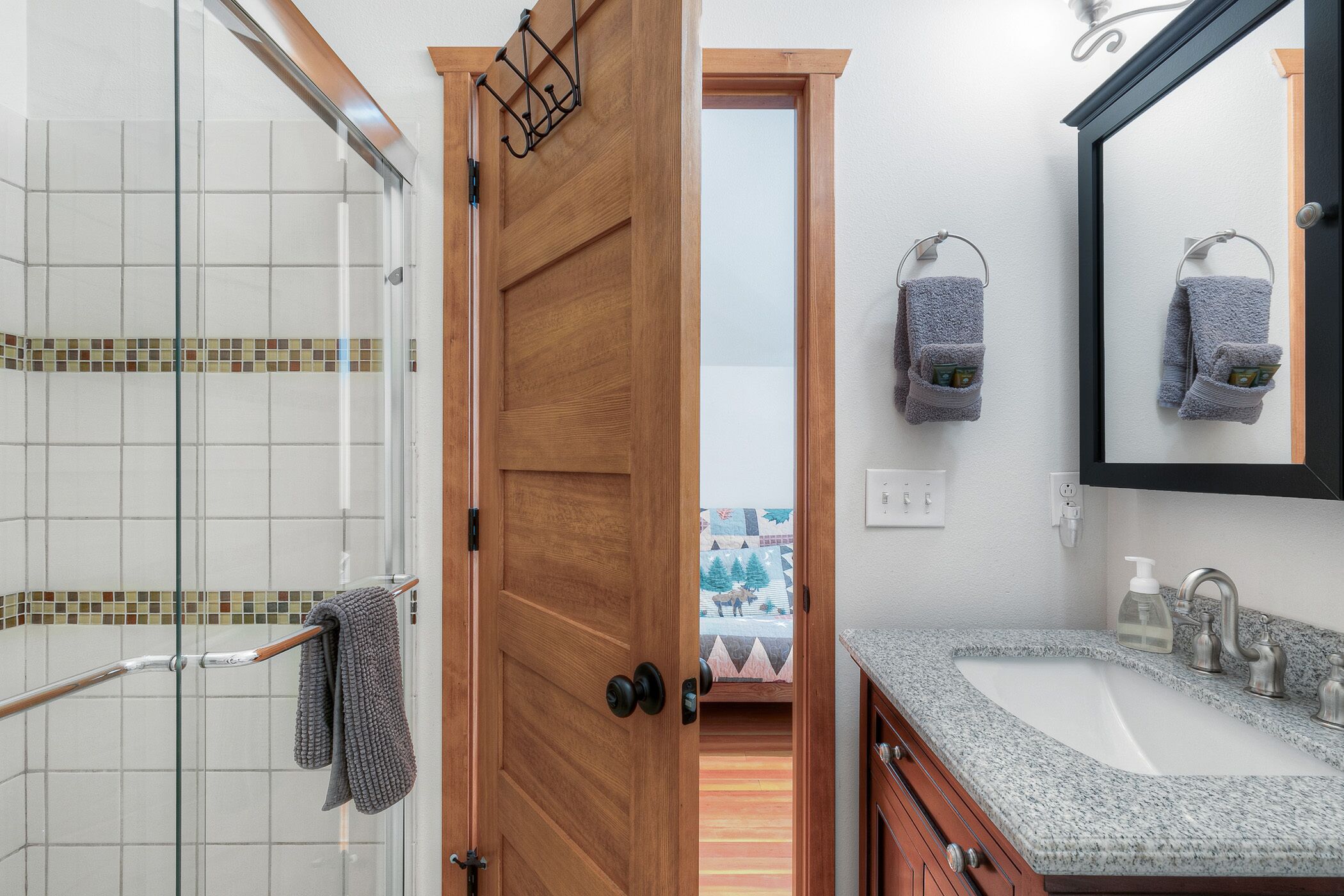 A bathroom with a shower, a sink, and a mirror.