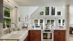 A modern kitchen with a large island, wooden cabinets, and a built-in oven.