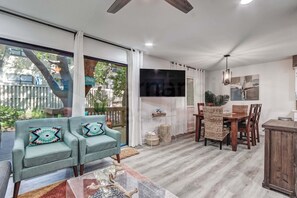 A spacious living area with a sofa, a dining table, and a TV. - New Listing - Dog Friendly - Recently Renovated - Multi-Level Condo - Short Walk to the Beach (Fernandina Beach)