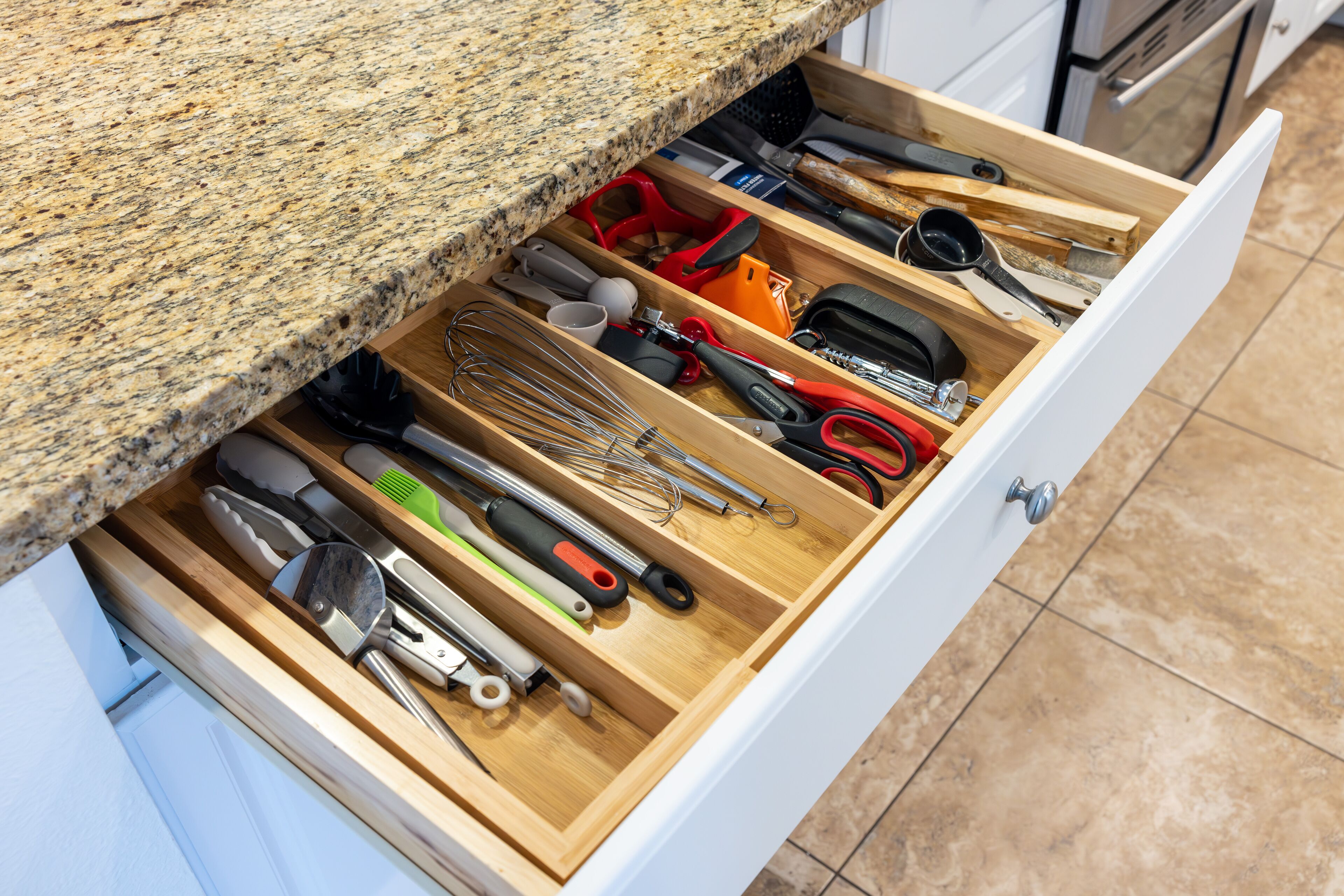 Un tiroir de cuisine contenant divers ustensiles et outils.