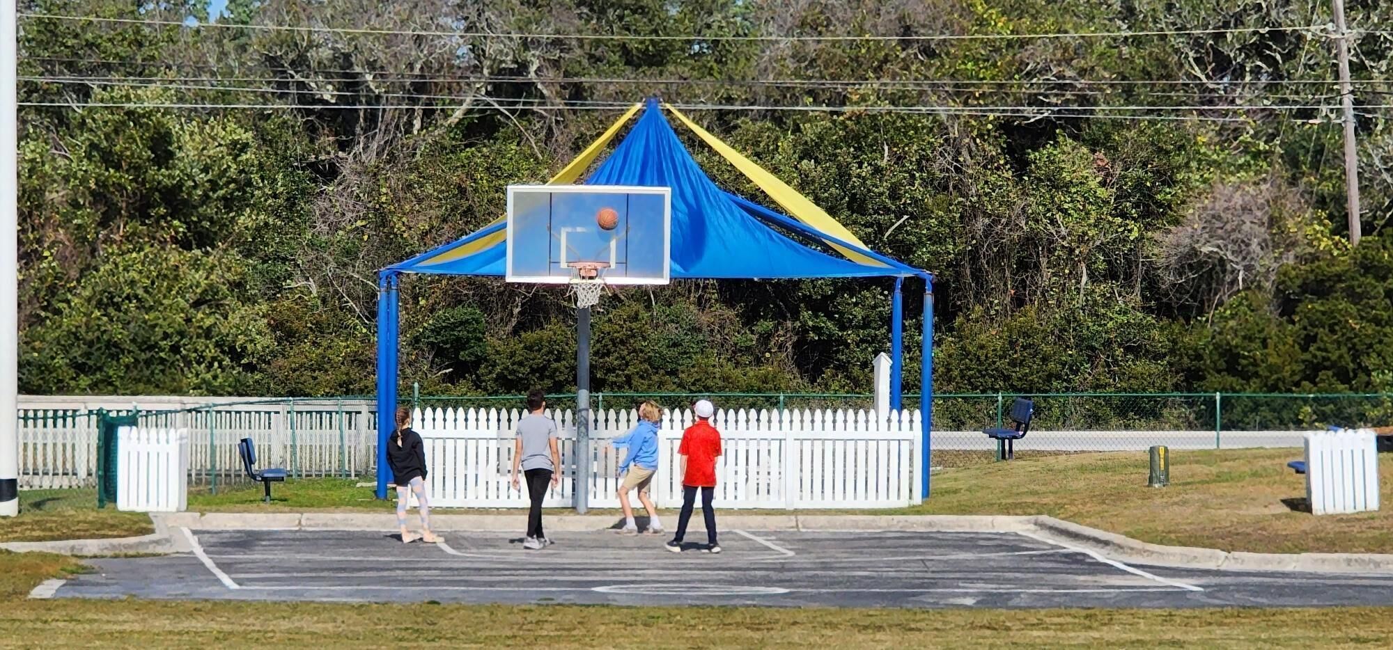 A basketball court with a blue and yellow tent structure.
