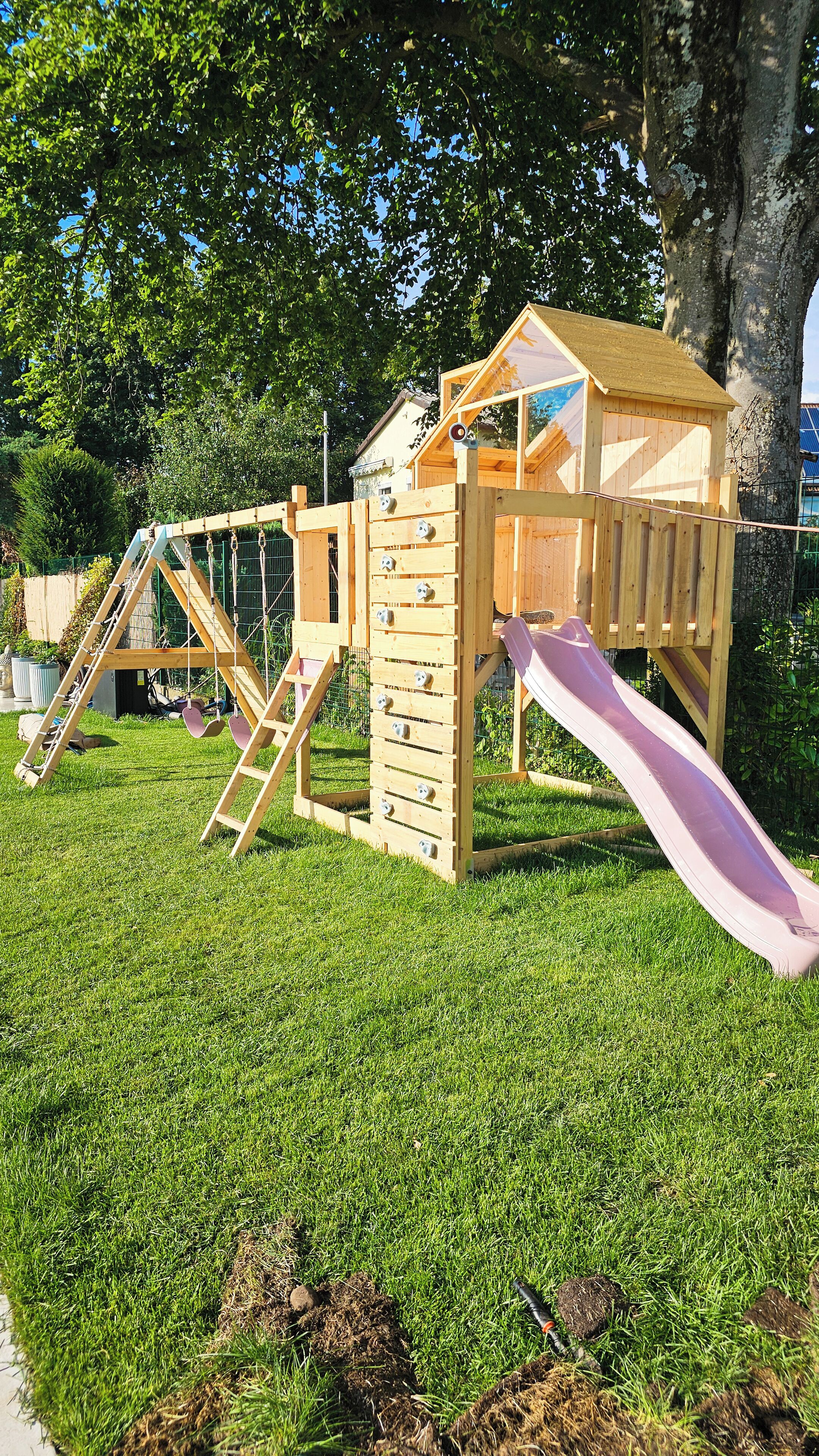 Una estructura de juego de madera con tobogán y elementos para escalar.