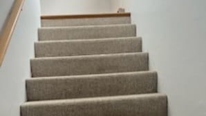 A carpeted staircase with a wooden handrail and white walls. - cozy 2 bedroom close to trails and boat launch three minutes (Richfield Township)
