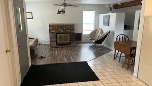 A living room with a fireplace, a dining table, and a ceiling fan. - cozy 2 bedroom close to trails and boat launch three minutes (Richfield Township)
