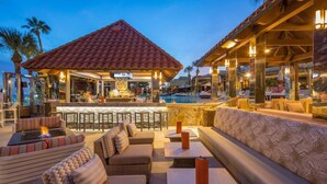 A resort bar with outdoor seating and a pool.