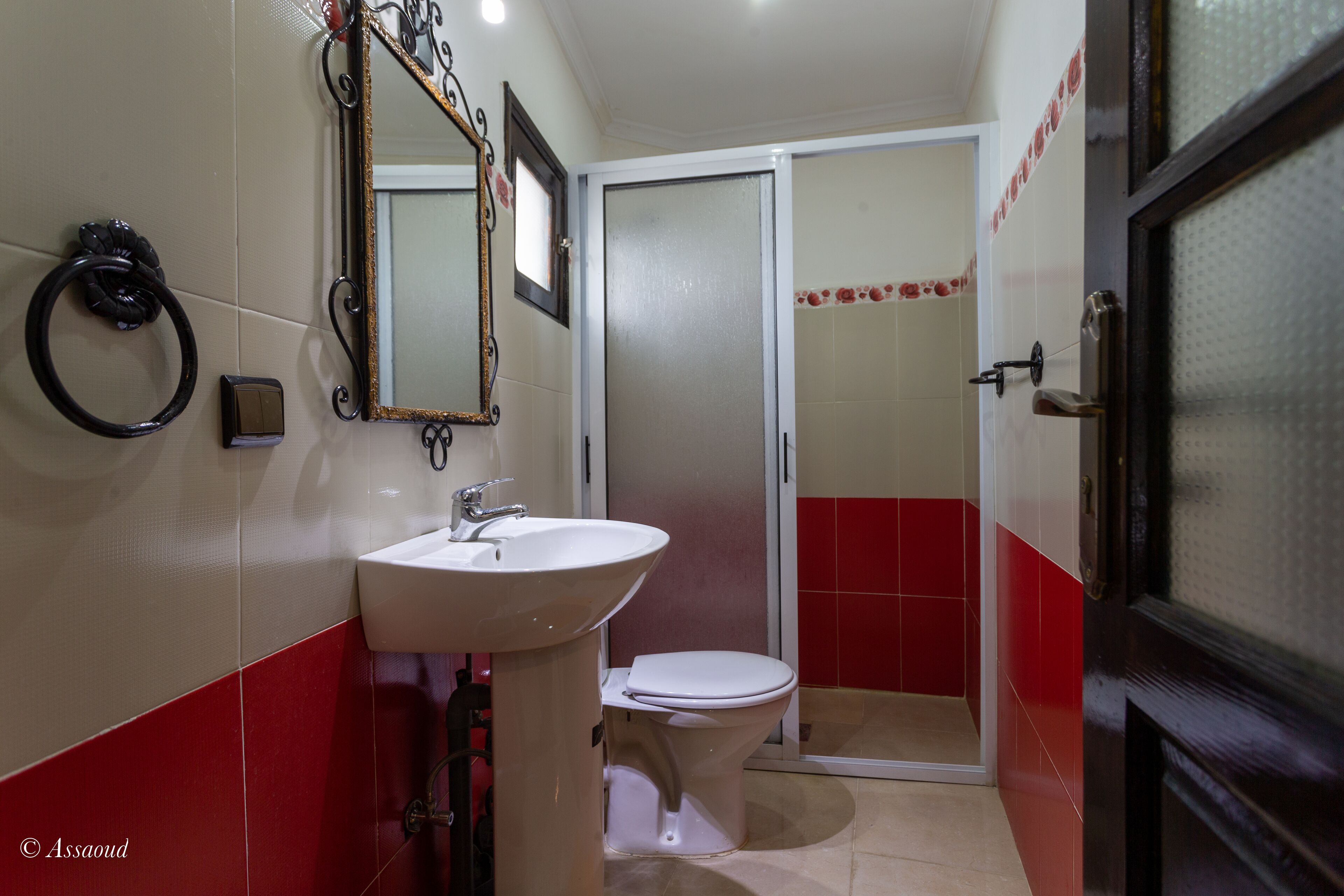 Un baño con lavamanos, inodoro y zona de ducha.