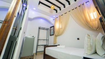 Un dormitorio con cama, armario, espejo e iluminación empotrada en el techo.