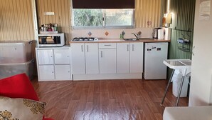 Una cocina compacta equipada con microondas, cocina a gas, lavaplatos y refrigerador.