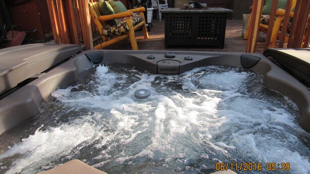 A hot tub with water jets, surrounded by wooden furniture and a star decoration.
