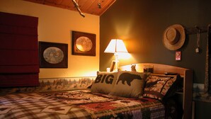 A bedroom with a bed, a lamp, and a wall clock.
