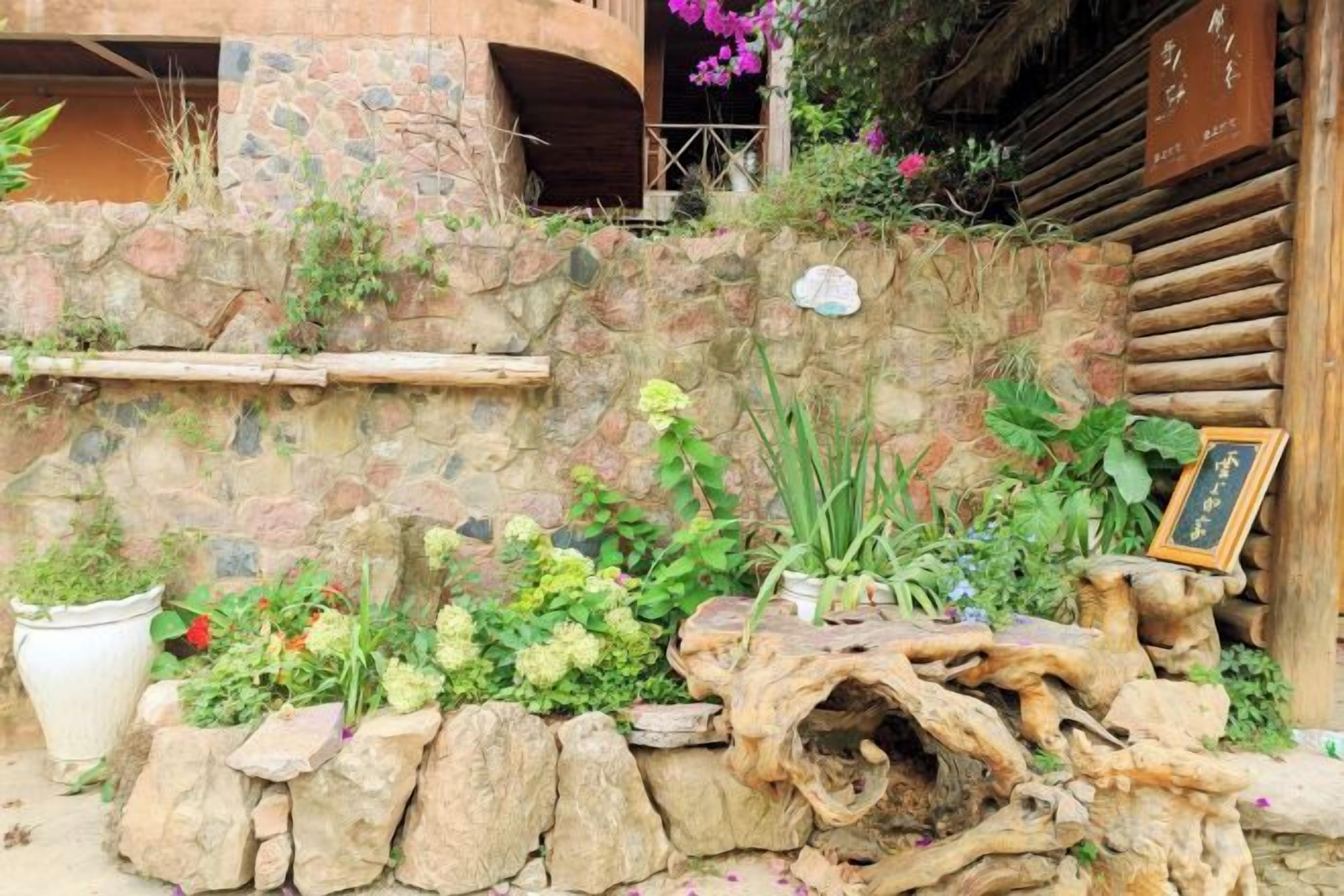 Un muro de piedra con plantas y una estructura de madera.