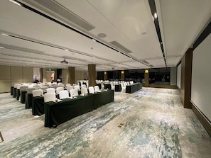 A conference room with rows of white chairs and tables, equipped with projectors and speakers, in a modern hotel setting. - Blossom Hill Hotel Nanjing Bojin (Nanjing)