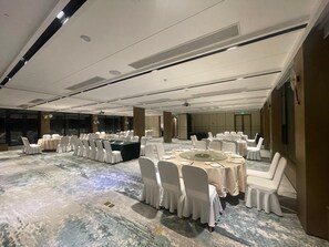 A conference room with round tables and white chairs, large windows, and a marble floor. - Blossom Hill Hotel Nanjing Bojin (Nanjing)