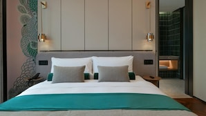 A modern hotel room with a large bed, a peacock mural, and a view of a tiled wall. - Blossom Hill Hotel Nanjing Bojin (Nanjing)