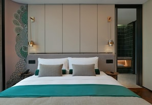 A modern hotel room with a large bed, a peacock mural, and a view of a tiled wall. - Blossom Hill Hotel Nanjing Bojin (Nanjing)