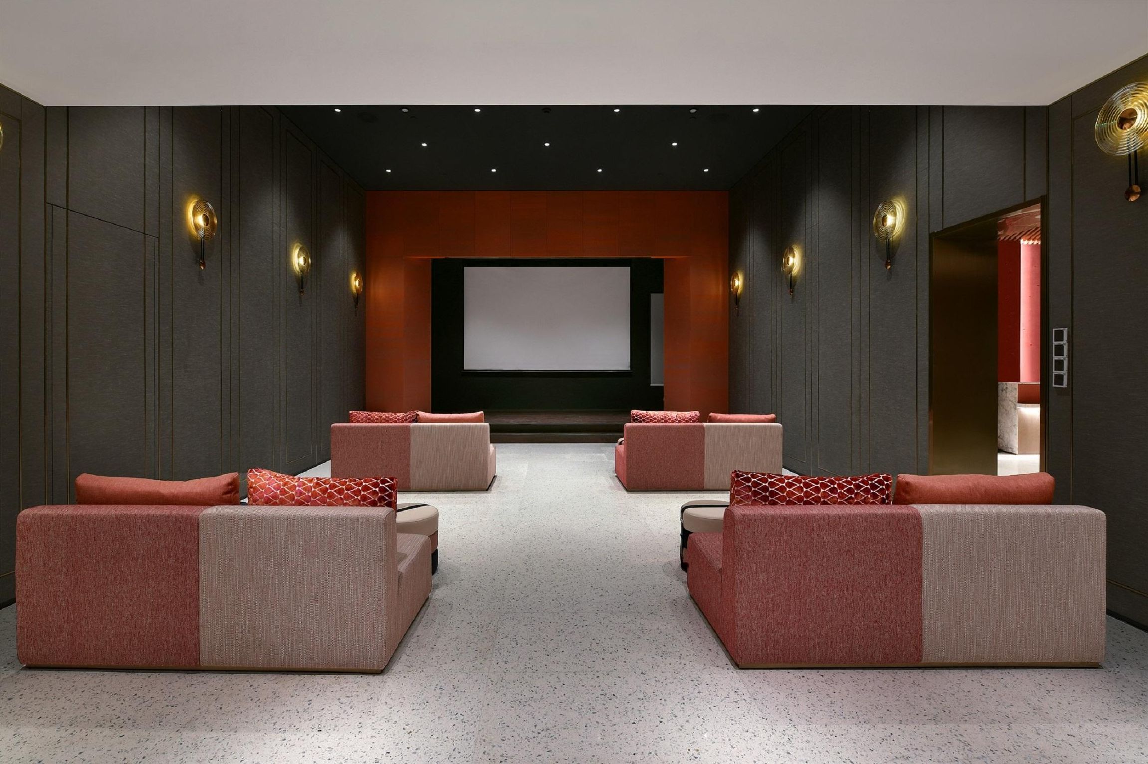 A modern home theater with a large screen, plush seating, and ambient lighting.