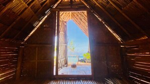 Vista interior de una estructura de madera con techo inclinado y una puerta que da al exterior.