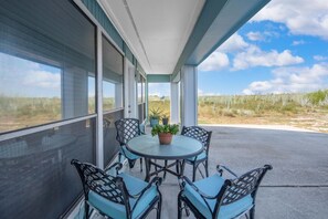 Un espace extérieur abrité, avec une table et des chaises, offrant une vue sur un paysage naturel.