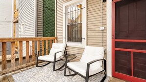 A porch with two rocking chairs, a wooden railing, and a patterned rug. - Cozy two bedroom close to Wrigley Field (Chicago)