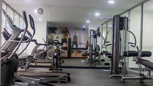 A gym with various exercise equipment, including treadmills and weight machines, arranged in rows. -  “Sea View Apartment: Near Airport. Air,C. Free Parking.” (San Miguel)