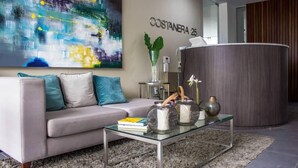 A modern living room with a grey sofa, a glass coffee table, and a large abstract painting on the wall. - “Sea View Apartment: Near Airport. Air,C. Free Parking.” (San Miguel)