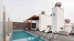 A rooftop pool with lounge chairs and a pergola. - “Sea View Apartment: Near Airport. Air,C. Free Parking.” (San Miguel)