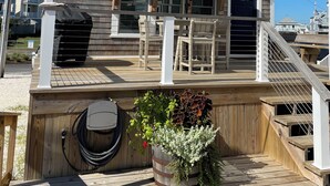 Una casa de dos pisos con un balcón, un patio cubierto y un ventanal grande.