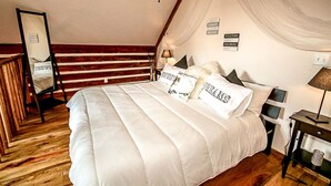 Un dormitorio con una cama grande, suelo de madera, un espejo y una pared con un cartel que dice "TOGETHER IS OUR FAVORITE PLACE".