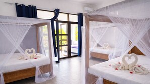 A hotel room with two beds, each with a canopy and heart-shaped towels. - Majani Breeze Zanzibar (Nungwi)