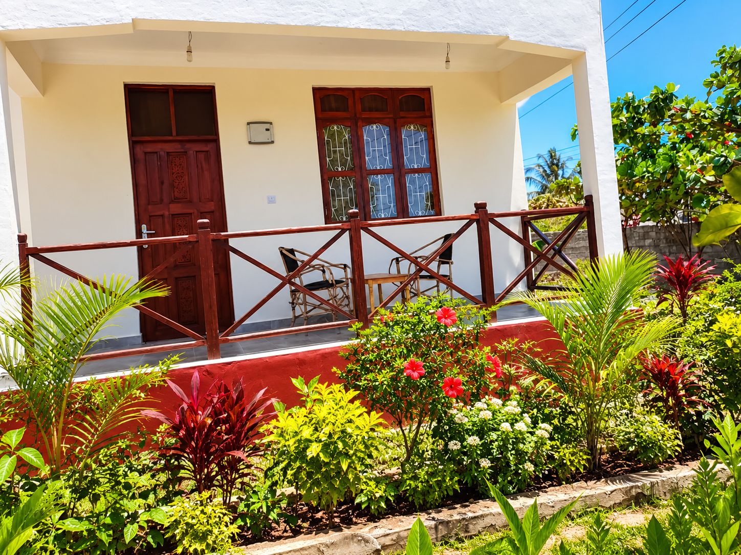 A building with a porch, two doors, and a railing.