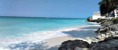 Ubicación cercana a la playa, arena blanca y toallas de playa