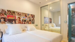 Une chambre à coucher avec un grand lit, une chaise et un mur décoré de photographies.