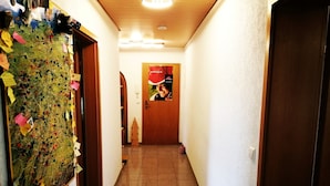 A hallway with a map on the left wall, a wooden door at the end, and a poster on the wall. - Apartment 'Villingen' with Balcony and Wi-Fi (Villingen-Schwenningen)