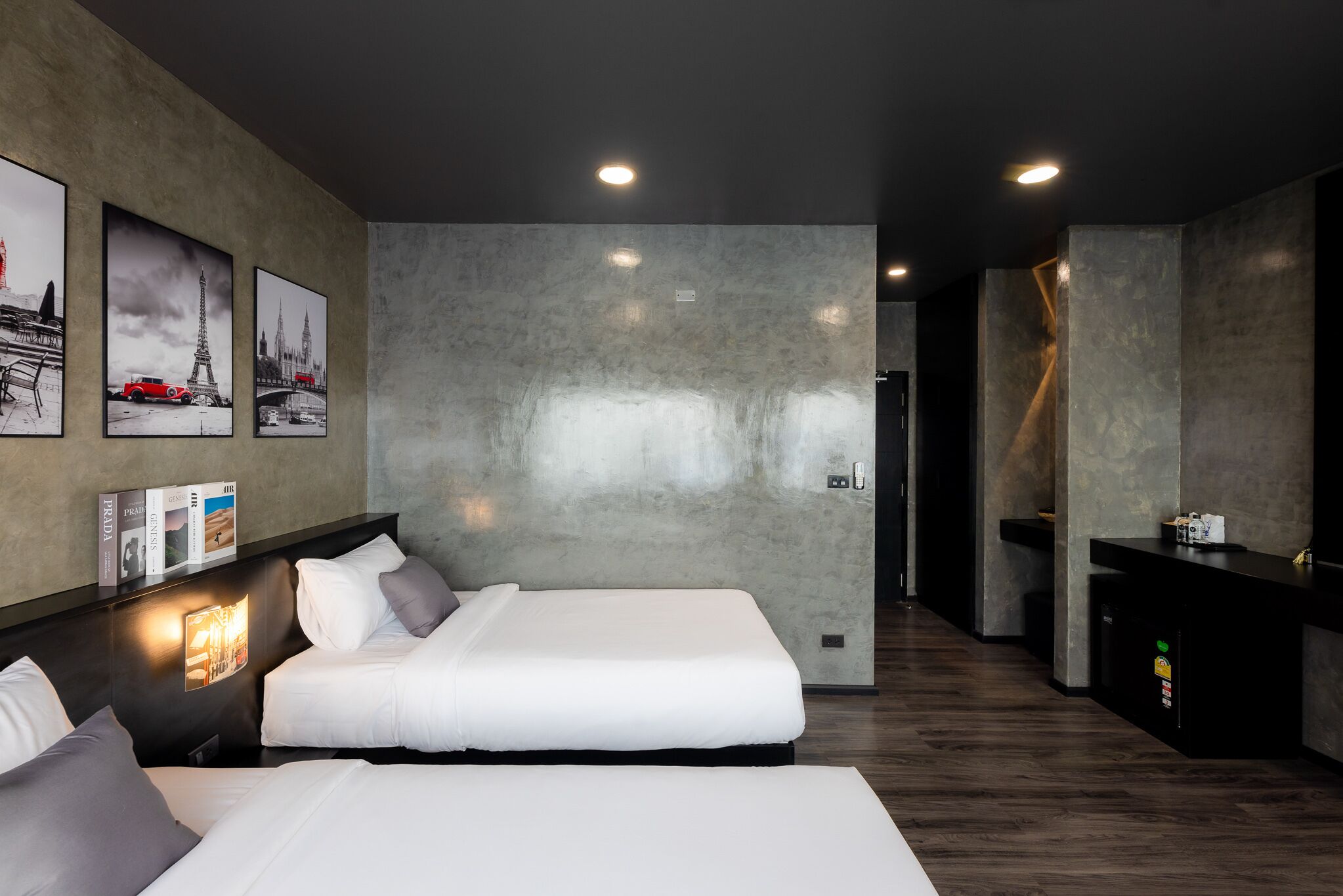 A modern hotel room with a large bed, a desk, and a minibar.
