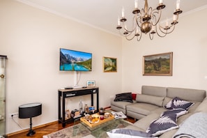 A living room with a sofa, a TV, a chandelier, and artwork on the walls. - Rustic Villa Okra With Pool, Opatija - Ičići, Croatia (Opatija - Ičići)