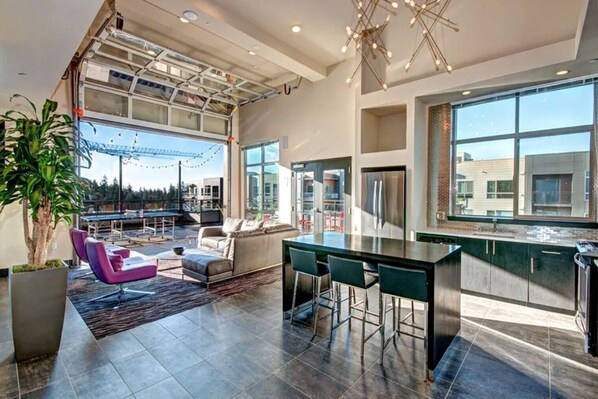 Relax in this spacious living area with a dining table, sofa, and chairs, offering views of the surrounding area.