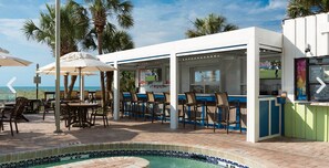 An outdoor bar area with seating and a pool.