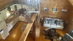 A wooden cabin interior with a dining area, kitchen, and living room. - Good Hope Cottage- Amish Country / fire pit (Lawrenceburg)