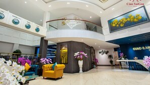 A hotel lobby with a central seating area, a reception desk, and a large painting on the wall. - Ciao SaiGon 2 Hotel (Ho Chi Minh City)