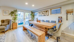 Un grand espace dédié à la salle à manger, avec une table en bois et des bancs, entourés de chaises.